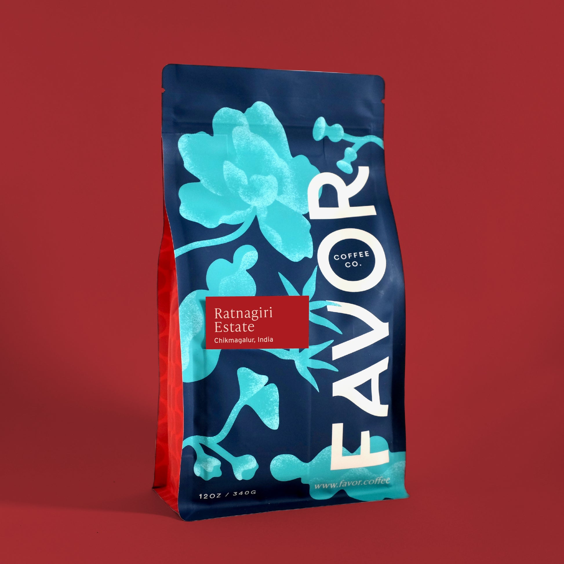 Coffee bag with blue floral design and 'FAVOR' branding on a red background. Tag on bag reads Ratnagiri Estate, Chikmagalur, India