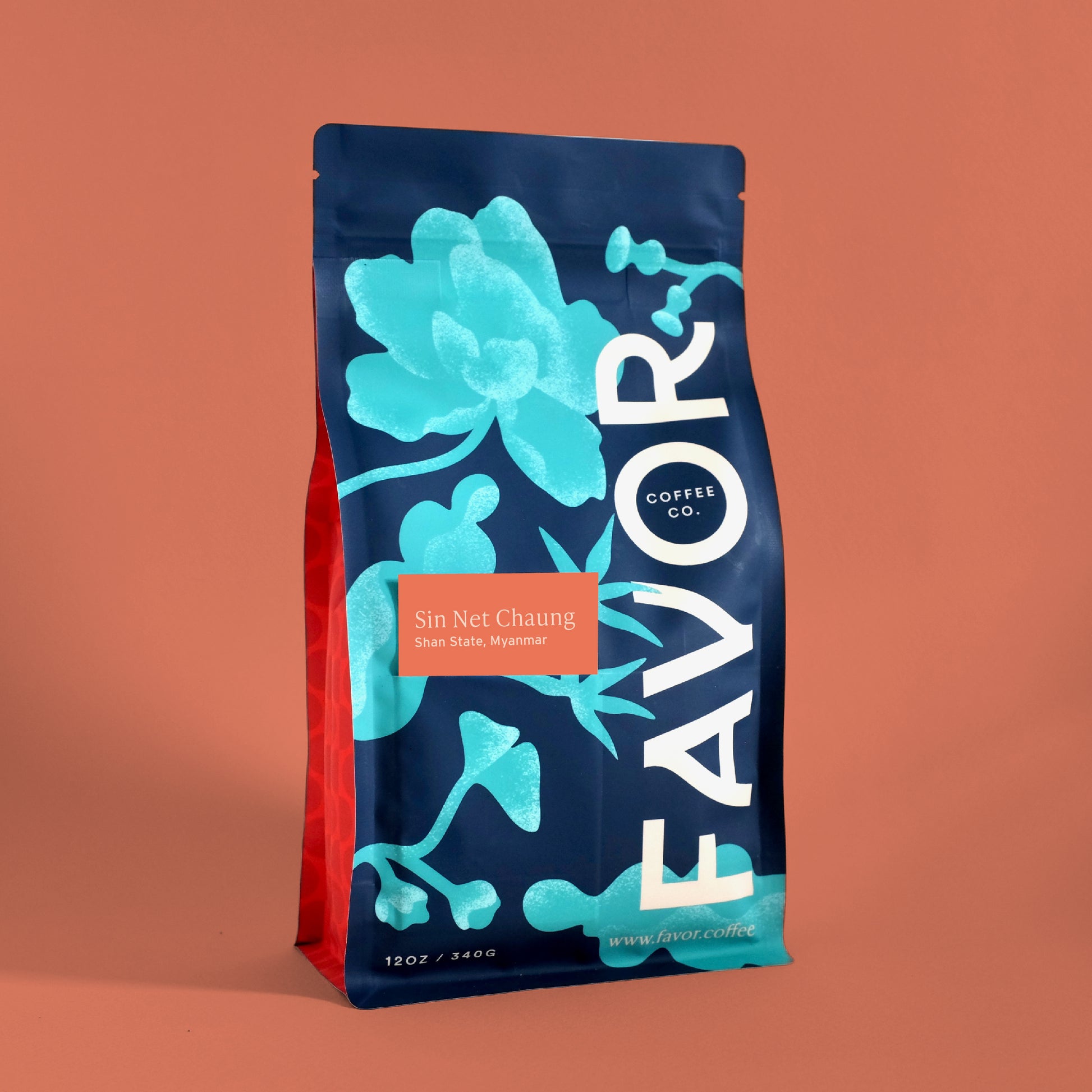 Coffee bag with blue floral design and 'FAVOR' branding on a pink background